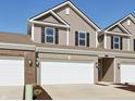 View of townhome showing a two-car garage, neutral siding, and simple landscaping at 6286 Wasco Dr, Whitestown, IN 46075