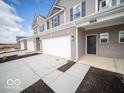 A modern townhome featuring a two-car garage, black front door, and well-maintained landscaping at 6296 Wasco Dr, Whitestown, IN 46075