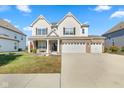 Beautiful two-story home boasting a large concrete driveway, three-car garage, and a welcoming front porch at 1220 Greenwood Station Blvd, Greenwood, IN 46143