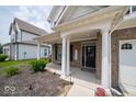 Covered front porch of this home is supported by white columns with a seating bench at 1220 Greenwood Station Blvd, Greenwood, IN 46143