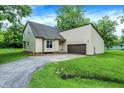 Lovely home with an attached garage, complemented by a verdant lawn and blue skies above at 2747 E Midland Rd, Indianapolis, IN 46227