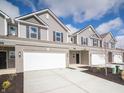 New construction townhome with a two-car garage, brick accents and landscaped front yard at 6314 Wasco Dr, Whitestown, IN 46075