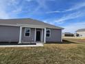Rear view of townhome with gray siding and small patio at 6330 Wasco Dr, Whitestown, IN 46075