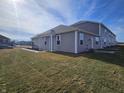 Side view of townhome showcasing gray siding and landscaping at 6330 Wasco Dr, Whitestown, IN 46075