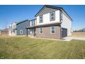 View of the side exterior of the home with lawn and neighboring houses, under a clear, sunny sky at 7888 Magnolia St, New Palestine, IN 46163