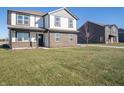 View of the front exterior of the home with lawn and neighboring houses, under a clear, sunny sky at 7888 Magnolia St, New Palestine, IN 46163