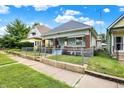 View of home with blue siding, brick details, and a chain-link fence, displaying its curb appeal on a sunny day at 1127 S Pershing Ave, Indianapolis, IN 46221