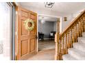 Bright entryway with a wooden front door, staircase, and an open view to a study at 10909 Wonderland Dr, Indianapolis, IN 46239