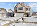 Inviting two-story home with a two-car garage, stylish exterior, and a pathway leading to the front door in snowy conditions at 5143 Rolling Meadow Blvd, Indianapolis, IN 46237