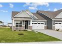 Charming home featuring a two-car garage, stone accents, manicured lawn, and a welcoming front porch at 3544 Wrangler Dr, Bargersville, IN 46106