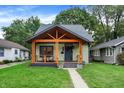 Beautiful single-story home featuring a covered front porch and lush green lawn at 6129 Crittenden Ave, Indianapolis, IN 46220