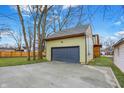 View of the detached garage with a new driveway and well maintained lawn at 6129 Crittenden Ave, Indianapolis, IN 46220