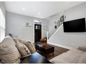 Cozy living room with modern decor, hardwood floors, and a staircase at 6129 Crittenden Ave, Indianapolis, IN 46220