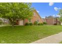 Brick house with a two-car garage featuring well-maintained greenery and lawn at 603 Ophelia Dr, Avon, IN 46123