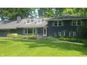 Inviting two-story residence with a lush green lawn and colorful garden beds enhancing its curb appeal at 6205 Bramshaw Rd, Indianapolis, IN 46220
