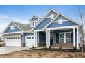Two-story home with blue siding, white trim, and a three-car garage at 15786 Vitalize Run, Fishers, IN 46040