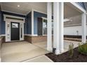 Inviting front porch with a dark blue exterior and brick base at 15786 Vitalize Run, Fishers, IN 46040