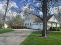 Well-maintained home exterior featuring an attached two-car garage, mature trees, and a freshly paved driveway in a suburban neighborhood at 1612 S Jeanne Ct, New Palestine, IN 46163