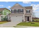 Traditional two-story home featuring gray siding, black shutters, a two-car garage, and a well-manicured lawn at 2260 Marjorie Way, Shelbyville, IN 46176