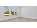 Bright living room featuring large windows and light wood-look floors at 300 N Bur Oak Dr, Mooresville, IN 46158
