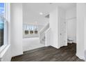 Spacious entryway featuring dark floors, stairs to the second floor, and view into the living area at 4832 E Shadowbrook Dr, Camby, IN 46113