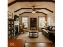 Comfortable living room features hardwood floors, a fireplace, beamed ceilings, and well-placed windows for natural light at 610 E Morgan St, Martinsville, IN 46151