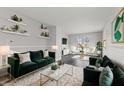Spacious living room with dark hardwood floors and green velvet sofas at 2103 Danbury Dr, Indianapolis, IN 46231