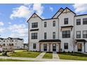 Charming new construction townhome with crisp white siding, black trim, covered entry, and well-manicured lawn at 4231 Barrel Ln, Westfield, IN 46062