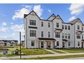 Charming new construction townhome with crisp white siding, black trim, covered entry, and well-manicured lawn at 4231 Barrel Ln, Westfield, IN 46062
