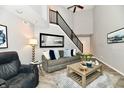 Inviting living room with high ceilings, modern decor, and a staircase at 7854 Harbour Isle, Indianapolis, IN 46240
