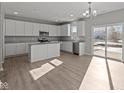 Bright, open kitchen with stainless steel appliances, an island, and sliding door access to the yard at 10133 Redwood Peak Ln, Indianapolis, IN 46259