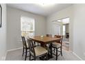 Elegant dining room boasts a four-chair dining table, large window, and neutral décor at 10476 Prairie Fox Dr, Fishers, IN 46037