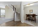 Spacious entryway featuring a staircase, hardwood floors, and seamless access to the dining room at 10476 Prairie Fox Dr, Fishers, IN 46037