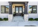 Welcoming entryway with a stylish double door, stone accents, and potted plants for added charm at 10937 Pete Dye Rdg, Zionsville, IN 46077