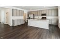 Modern kitchen with stainless steel appliances, gray cabinets, and an island at 7856 Magnolia St, New Palestine, IN 46163