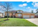 Charming brick home featuring a spacious lawn and three-car garage at 3719 Carwinion Way, Carmel, IN 46032