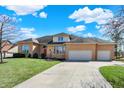 Charming brick home featuring a spacious lawn, three-car garage, and extended driveway at 3719 Carwinion Way, Carmel, IN 46032