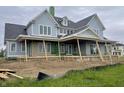 An exterior view of a new construction two-story home with light blue siding and a dark roof at 1717 Beaufain St, Carmel, IN 46032
