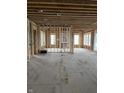 An unfinished living room with exposed studs and natural light pouring through the large windows at 1717 Beaufain St, Carmel, IN 46032