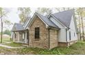 Brick and white farmhouse showcasing a side view at 4429 Village Dr, Anderson, IN 46012