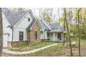 White and brick farmhouse with gray roof and a walkway at 4429 Village Dr, Anderson, IN 46012