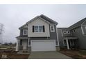 Two story home with an attached garage, covered entry way, and white trim at 5057 Modernist Blvd, Indianapolis, IN 46237