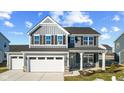 Two-story gray house with white garage doors, stone accents, and a covered porch at 250 Mcnair Rd, Whiteland, IN 46184