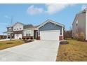 Charming single-story home with blue siding, brick accents, a two-car garage, and a well-manicured front yard at 10008 Sundley Dr, Indianapolis, IN 46239