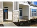 Inviting front porch with stone pillars, complementing the home's stylish exterior, leading to the entry at 15846 Vitalize Run, Fishers, IN 46040