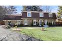 A beautifully landscaped home with a stone facade and mature trees at 6906 Johnson Rd, Indianapolis, IN 46220