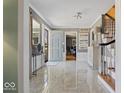Elegant foyer featuring marble floors and an open staircase with natural light at 6906 Johnson Rd, Indianapolis, IN 46220