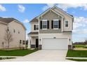 Charming two-story home featuring a gray and white color scheme, a two-car garage, and a well-manicured lawn at 1833 James Pierce Dr, Shelbyville, IN 46176