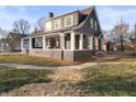 Eye-catching two-story house with a covered porch extending along the side and front at 1429 Brookside Pkwy N Dr, Indianapolis, IN 46201