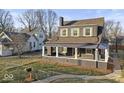 This two-story home boasts a covered front porch and beautifully maintained front yard at 1429 Brookside Pkwy N Dr, Indianapolis, IN 46201